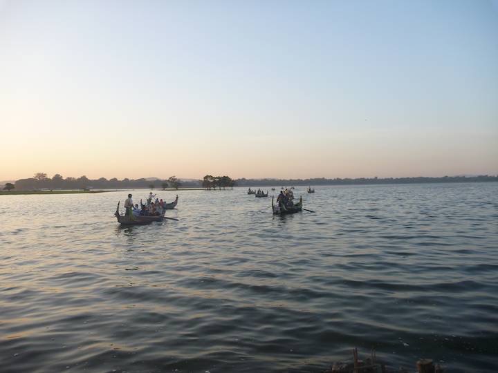 Bus tourists take small boats out onto the lake to see sunset